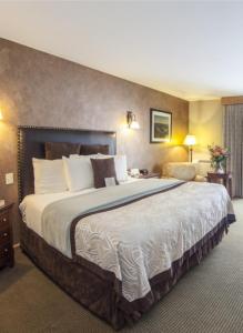 a hotel room with a bed and two lamps at Golden Arrow Lakeside Resort in Lake Placid