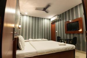 a hotel room with a bed and a tv at HOTEL PARK VICTORIA in Kolkata