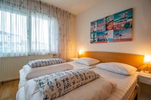 2 camas en una habitación con 2 lámparas y una ventana en Beach appartement 29 - Callantsoog, en Callantsoog