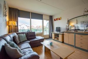 sala de estar con sofá y mesa en Beach appartement 29 - Callantsoog, en Callantsoog
