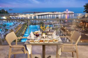 uma mesa com comida numa varanda com vista para o oceano em Mylome Luxury Hotel & Resort - Ultra All Inclusive em Okurcalar