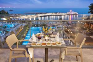 a table with food on a balcony with a view of the ocean at Mylome Luxury Hotel & Resort in Okurcalar