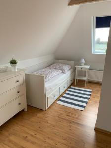 a bedroom with a bed and a dresser and a window at Nordseeblick Ferienhaus in Wobbenbüll