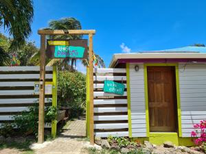ein kleines Haus mit Schildern davor in der Unterkunft Almost Paradise Cottage Retreats in Sauteurs