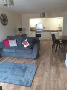 a living room with a blue couch and a table at Lovely coastal house in the western lake district minimum 3 night stay in St Bees