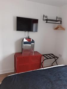 a bedroom with a red dresser with a tv on it at Lovely coastal house in the western lake district minimum 3 night stay in St Bees