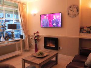 a living room with a fireplace and a tv on the wall at Seagull Hotel in Blackpool