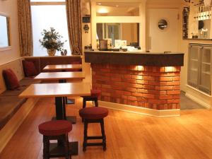 a bar with wooden tables and stools in a restaurant at Seagull Hotel in Blackpool