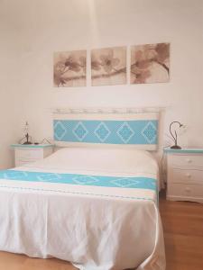 1 dormitorio con 1 cama y 2 cuadros en la pared en sweet home la maddalena en La Maddalena