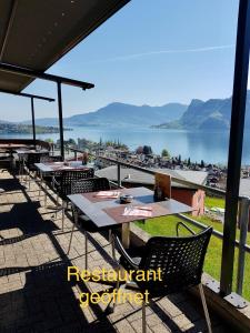 un restaurante con mesas y sillas y vistas al agua en Hotel Roggerli, en Hergiswil