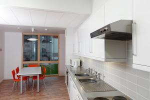 a kitchen with a sink and a table with chairs at Venue Reading Accommodation in Reading