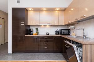 a kitchen with brown cabinets and a sink and a microwave at Stara Polana Apartamenty & Spa Zakopane by Noclegi Renters in Zakopane