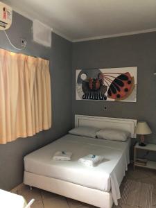 a bedroom with a bed with a ladybug picture on the wall at Hotel Graciosa Palace in Palmas