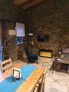 a living room with a table and a fireplace at Petradaki House in Arakapas