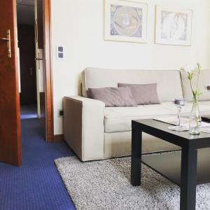 sala de estar con sofá blanco y mesa en RhönZeit Apartements und Zimmer, en Hilders