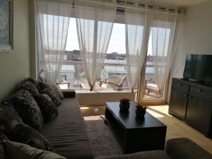 a living room with a couch and a large window at Aida 5 City Center Apartment in Pärnu