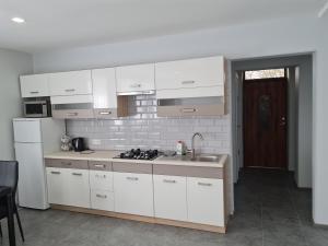 eine Küche mit weißen Schränken und einem Waschbecken in der Unterkunft Birutės apartamentai in Klaipėda