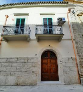 ein Haus mit 2 Balkonen und einer Holztür in der Unterkunft Il Giardino Nascosto B&B in Vasto