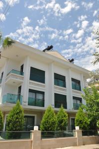a white building with trees in front of it at X SUITE APART in Fethiye