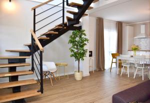 a living room and dining room with a spiral staircase at Villa Vedran in Podgora