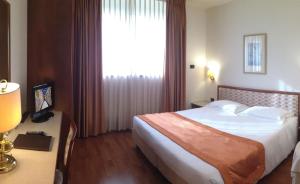 una camera d'albergo con un letto e una grande finestra di Hotel Marconi a Padova