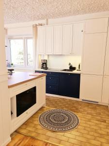 a kitchen with white cabinets and a blue sink at Baltic House in Kopalino