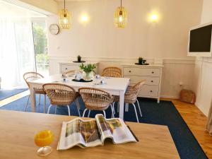 a dining room with a white table and chairs at Baltic House in Kopalino