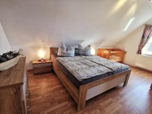 Schlafzimmer mit einem Bett und Holzboden in der Unterkunft Ferienhaus Scharhörn in Horumersiel