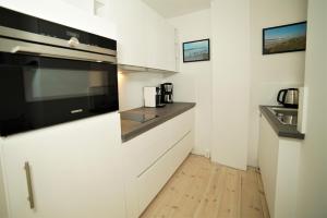 a kitchen with white cabinets and a sink at Speicher Residenz Barth E4 App 7 in Barth