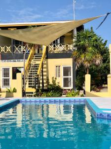 a house with a swimming pool in front of a house at The Novelo in Caye Caulker