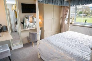 a bedroom with a bed and a mirror and a chair at The Cottage Tea Room B&B in Kettlewell +7 photos
