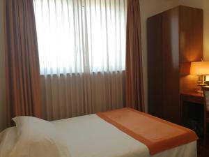 A bed or beds in a room at Hotel Marconi