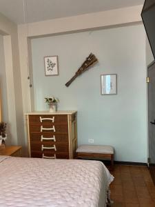 a bedroom with a bed and a dresser and a sword on the wall at The Bambu Room at Casa of Essence located in heart of Old San Juan in San Juan