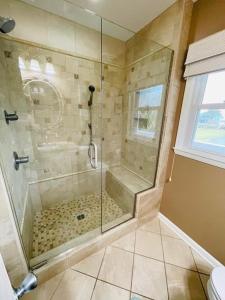 a shower with a glass door in a bathroom at Beach Bells Home in Holden Beach