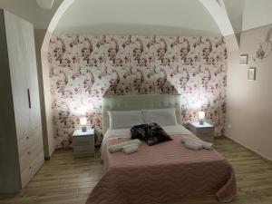 a bedroom with a large bed with a pink floral wall at The house Porta Garibaldi in Catania