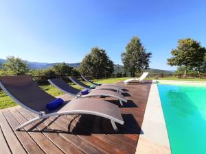 a row of lounge chairs next to a swimming pool at Villa Galearpe with private pool in Tuscany in Salutio