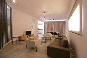 a living room with a couch and chairs and a television at Villa Yria in Coral Bay