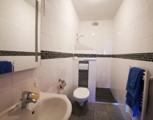 a white bathroom with a toilet and a sink at Stadtdomizil in Augsburg