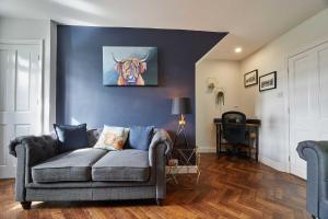 ein Wohnzimmer mit einer Couch und einem Gemälde eines Tigers in der Unterkunft Host & Stay - Cummins & Goings Cottage in Barnard Castle