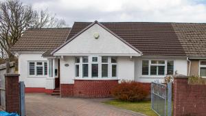 a white house with a brown roof at Large family Bungalow, parking & Bike Store BPW in Merthyr Tydfil