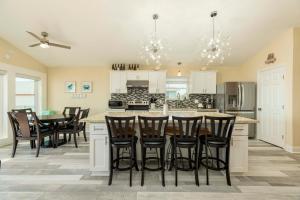 a kitchen with a large island with bar stools at On Galveston Bay Spacious Home with Pier and Grills! in San Leon +28 photos