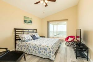 a bedroom with a bed and a ceiling fan at On Galveston Bay Spacious Home with Pier and Grills! in San Leon