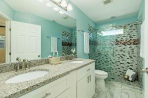 a bathroom with two sinks and a toilet and a shower at On Galveston Bay Spacious Home with Pier and Grills! in San Leon