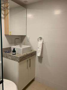 a white bathroom with a sink and a shower at Canto da Sereia in João Pessoa