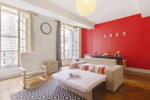 a living room with red walls and a couch at Flat in the historic heart 2min to the river - Bayonne - Welkeys in Bayonne