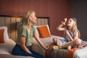 two girls sitting on a bed in a hotel room at Midlands Park Hotel in Portlaoise