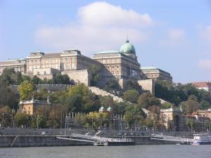 a large building on a hill next to the water at Attila Hotel in Budapest