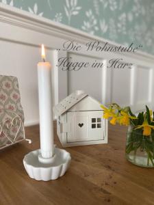 uma vela e uma casa de pássaros sentados numa mesa em "Die Wohnstube"-Hygge im Harz em Wernigerode