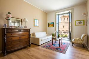a living room with a white couch and a dresser at Cathedral View Apartments in Palermo