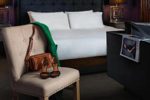 a pair of shoes sitting on a chair next to a bed at Midlands Park Hotel in Portlaoise